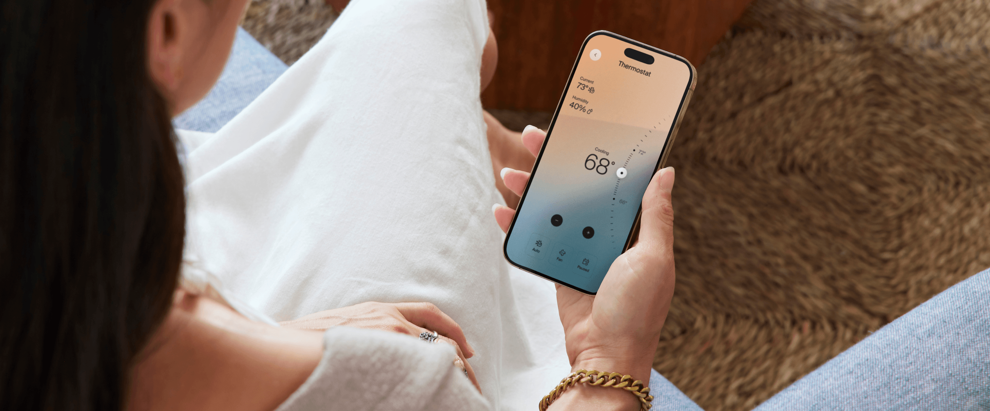 apartment resident holding smartphone with smart apartment app to control thermostat
